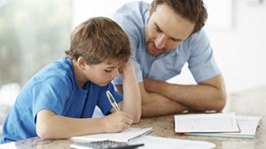 Papa helpt zoon met huiswerk