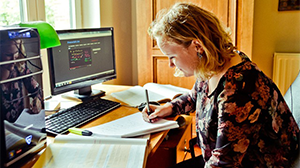 Leerling maakt huiswerk achter computer thuis