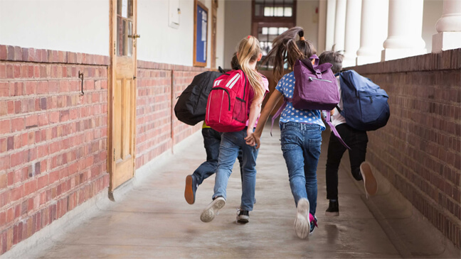 Leerlingen rennen door de schoolgang