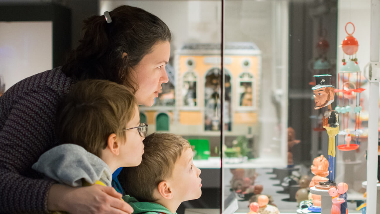 Gezin kijkt naar pop in speelgoedmuseum