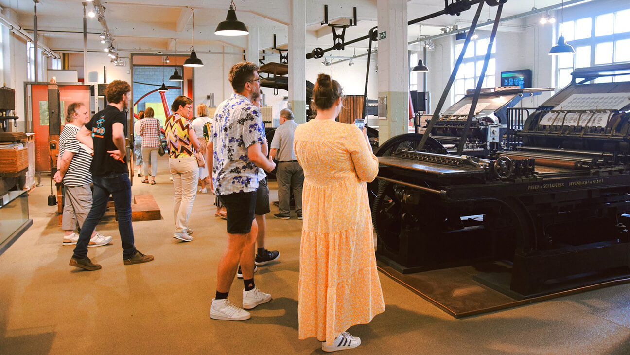 bezoekers in de drukkerij van het nationaal museum van de speelkaart