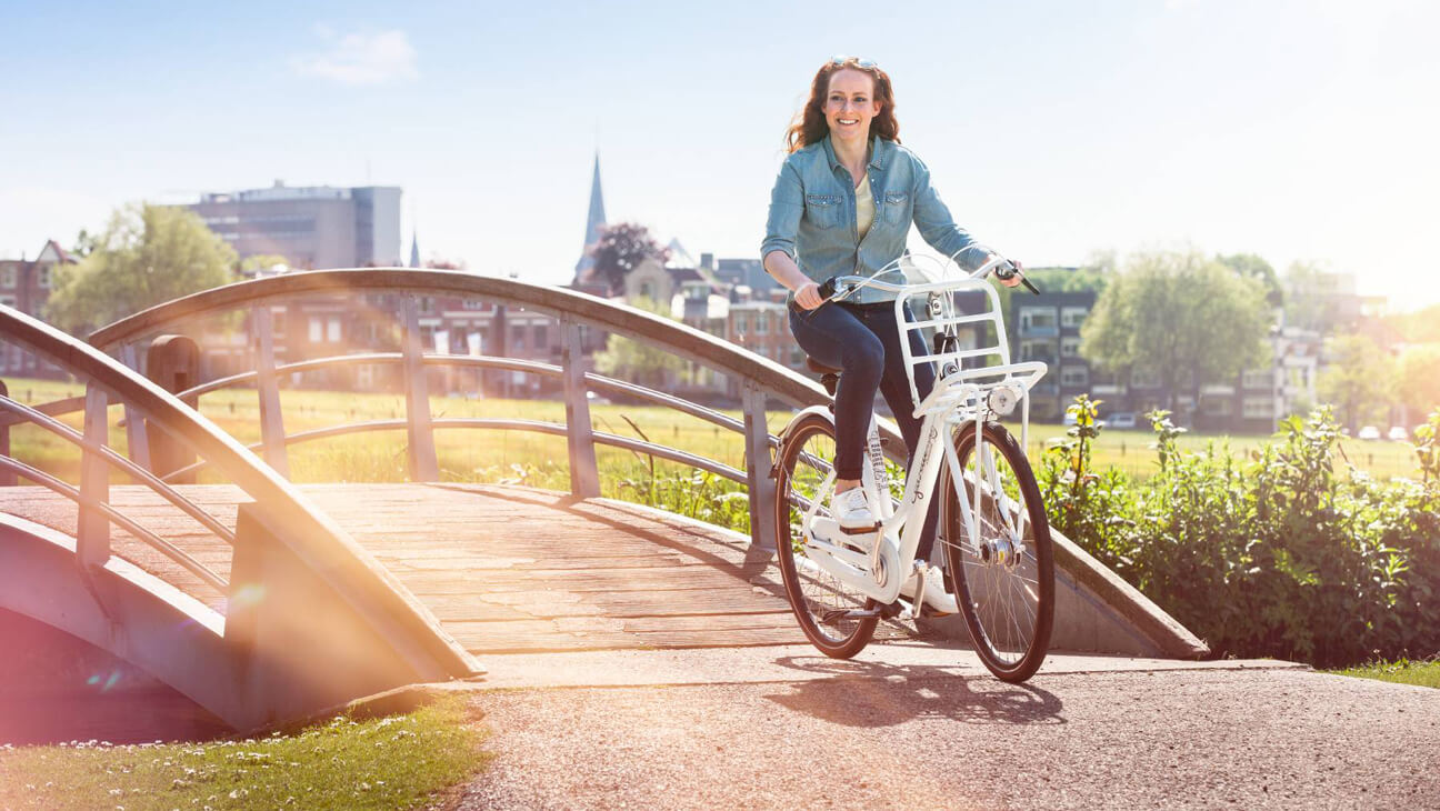 Vrouw fiets over brugje