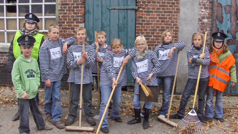 Kinderen poseren met een gevangenistenue