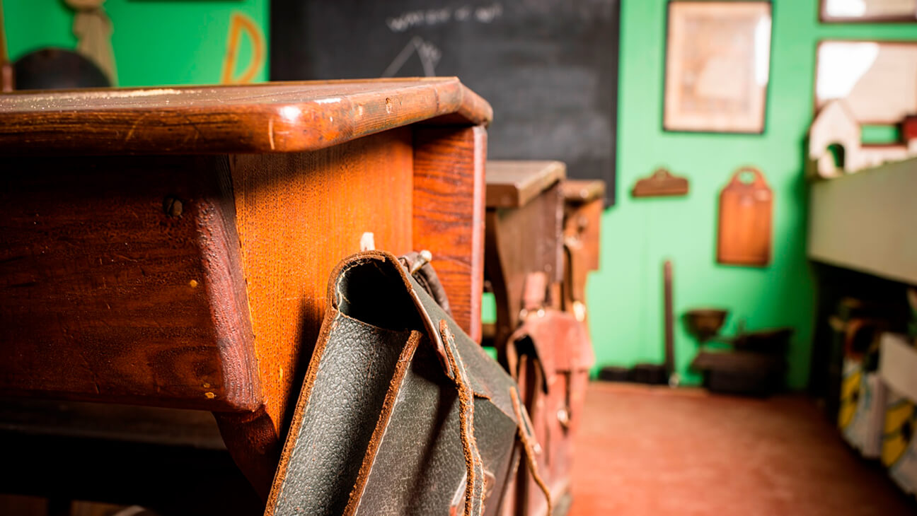 Oude schoolbanken en boekentas in Heemmuseum Het Molenijzer