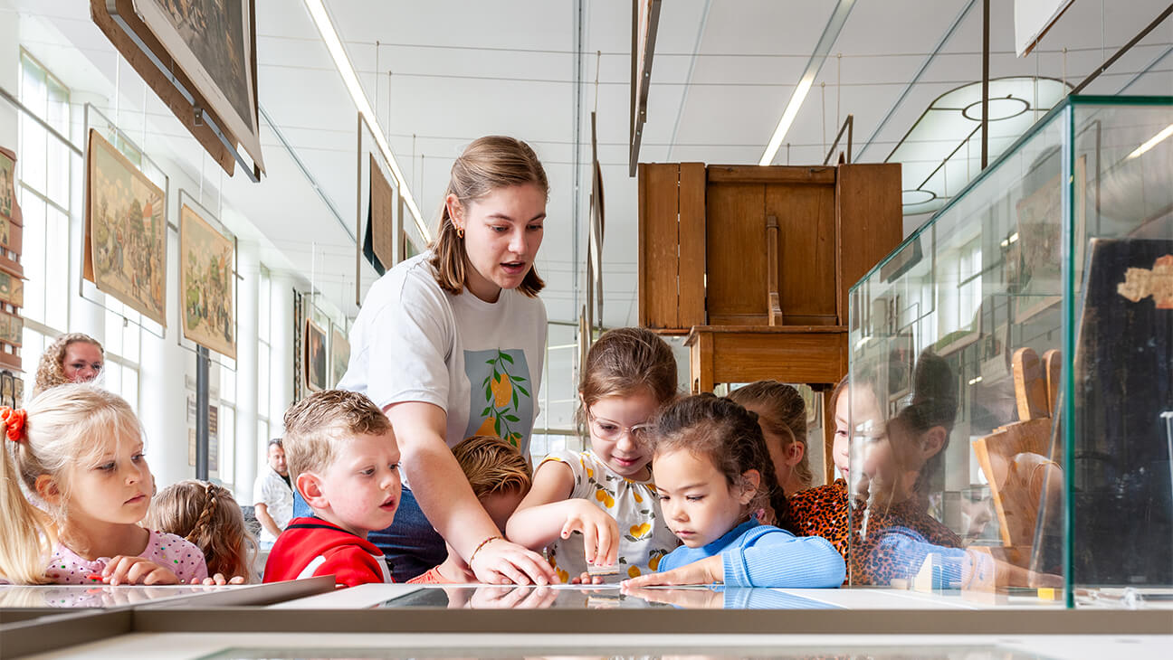 Gids met leerlingen in het Nationaal Onderwijsmuseum