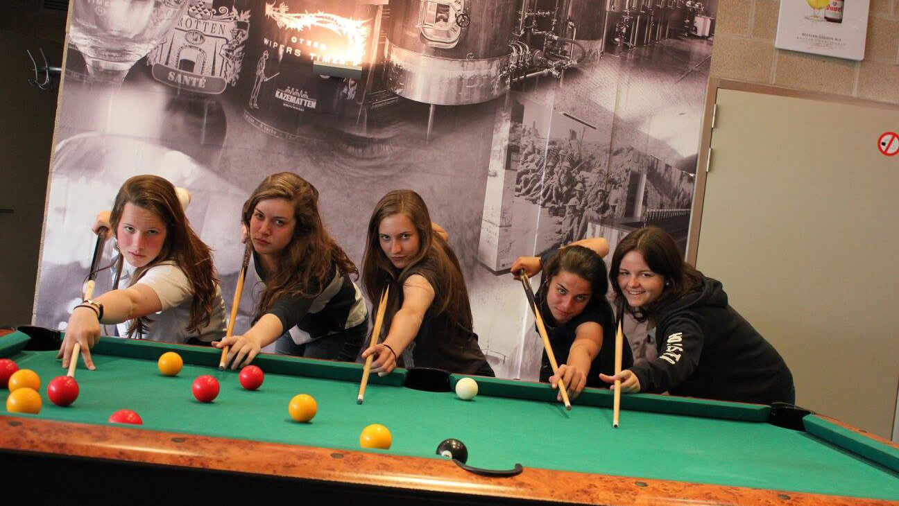 Meisjes aan een biljarttafel in Peace Village Hostel