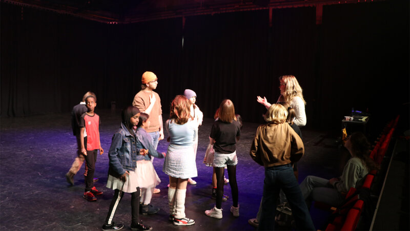 Kinderen op het podium in theaterzaal antigone