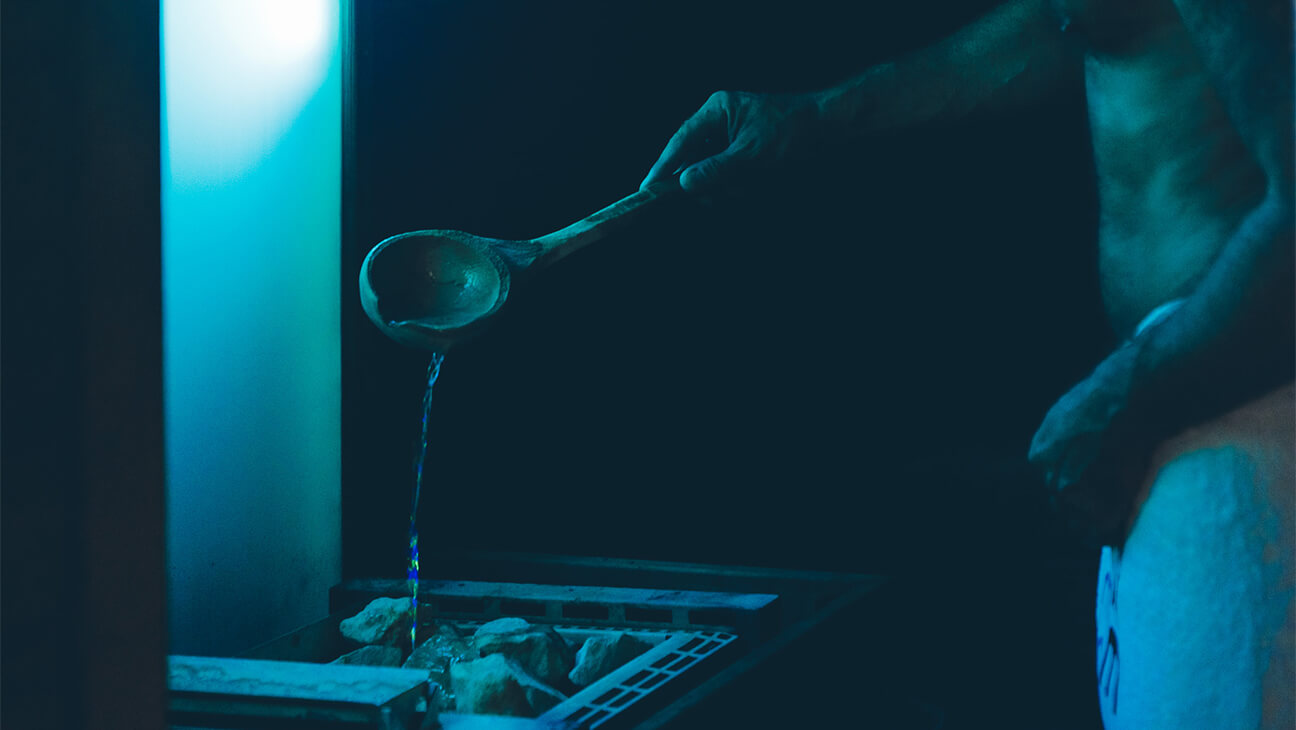 Man gooit water op sauna bij Pure Senses 24/7 fit- & wellness club