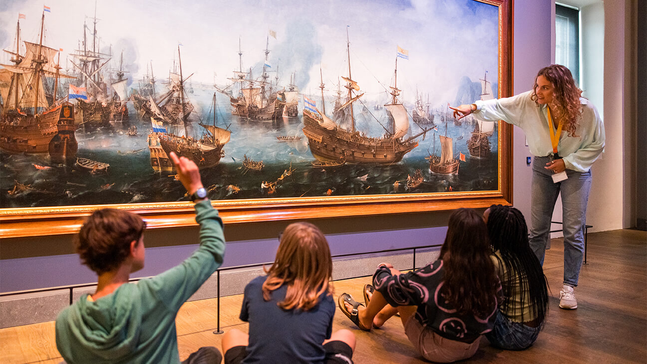 Klas kijkt naar een schilderij van een schip in het scheepvaartmuseum