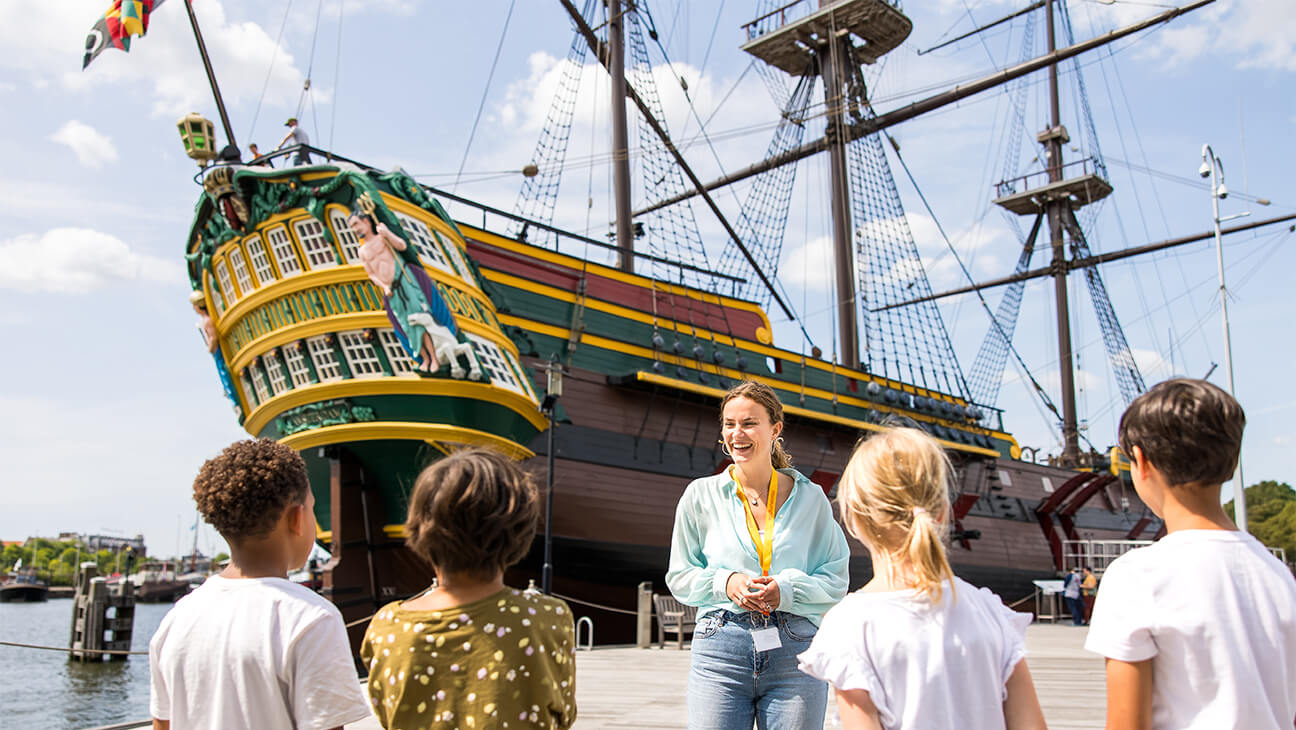 Klas met gids bij het VOC ship in het scheepvaartmuseum