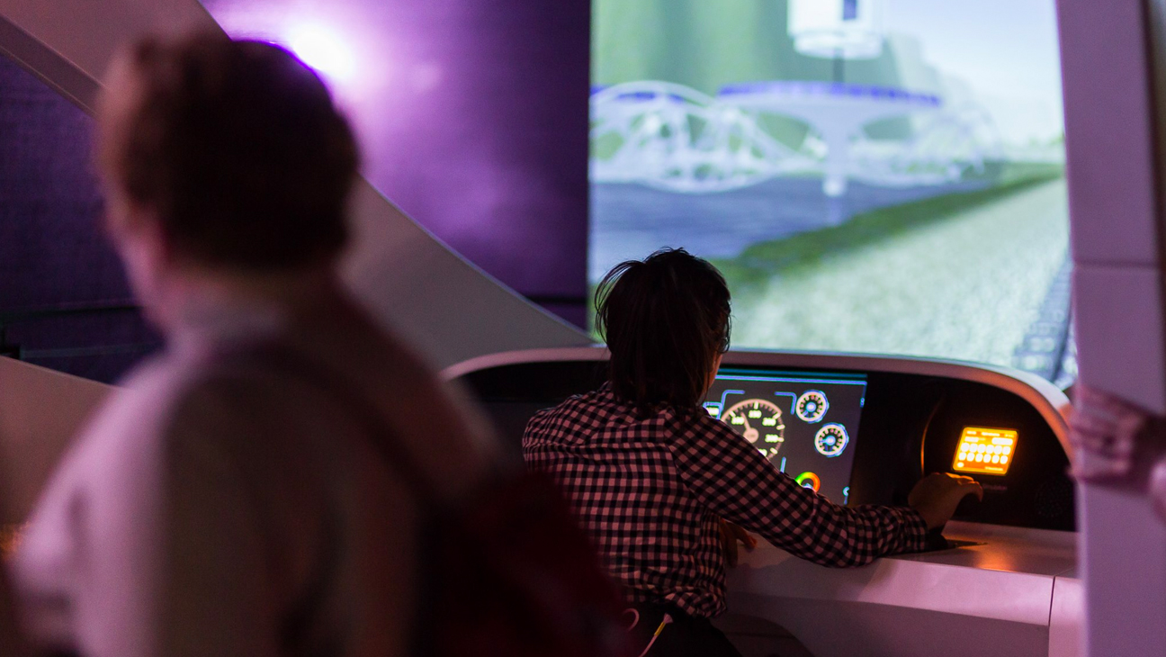 Jongen aan het stuur van treinsimulator in Train World