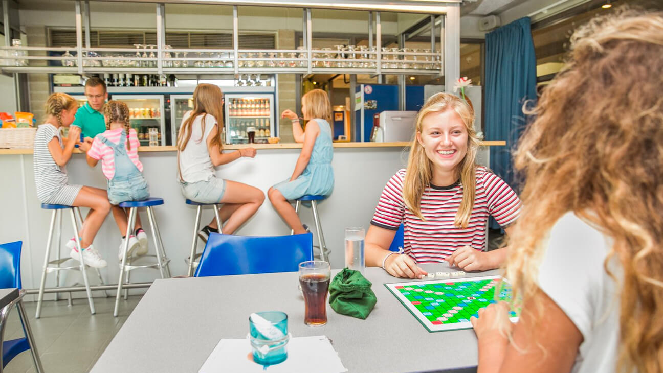 Jongeren spelen scrabble aan tafel