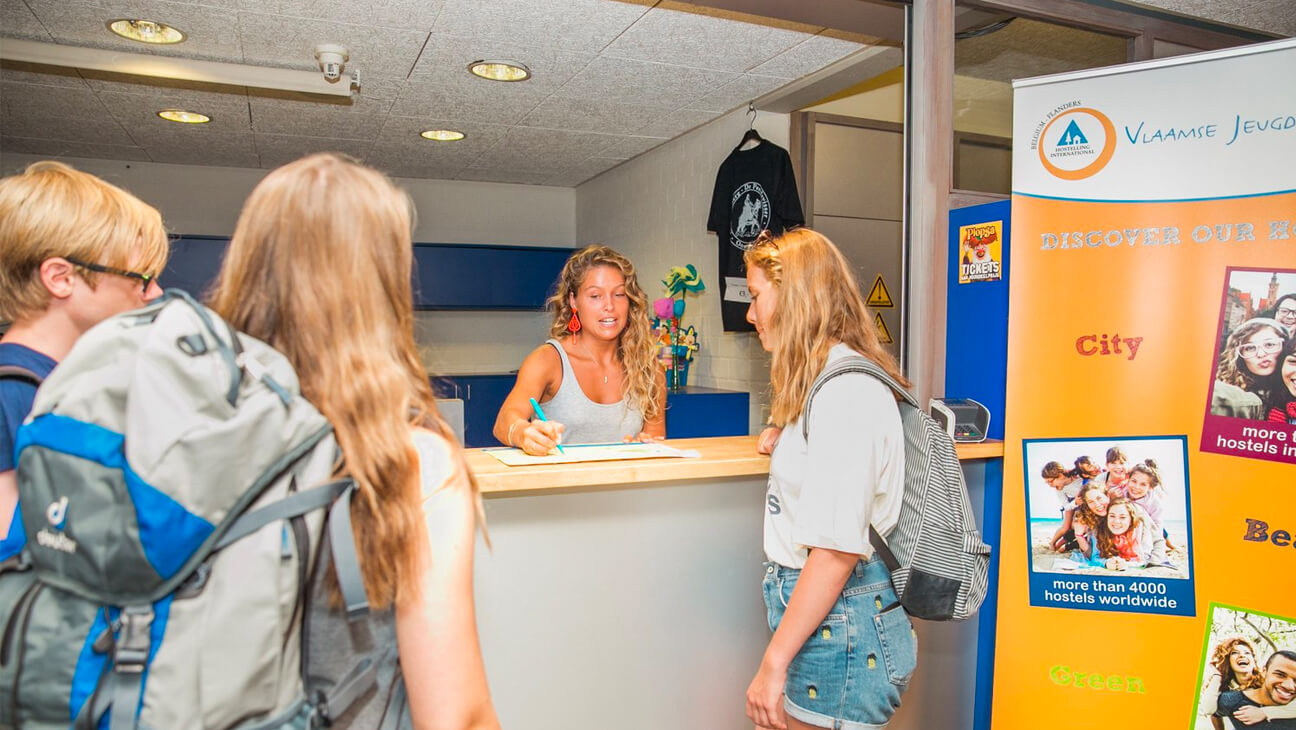 Jongeren aan de balie in een Vlaamse jeugdherberg