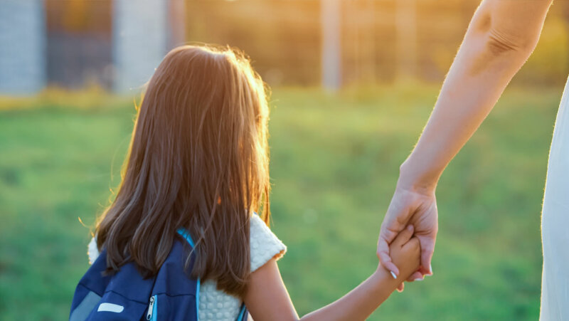 moeder brengt dochter naar school