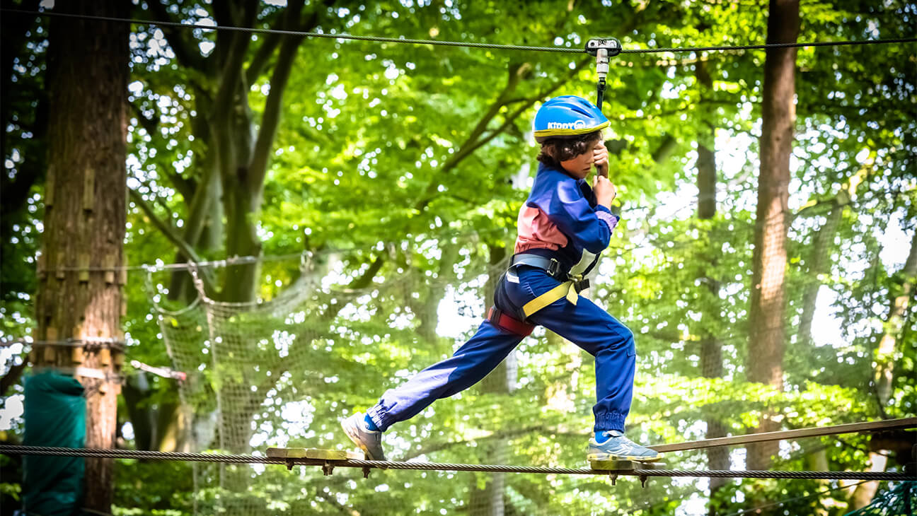 Kind op een klimparcours in Aventure Parc Wavre