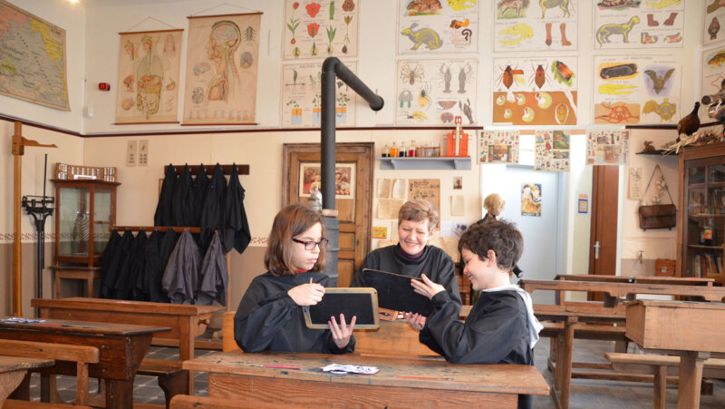 Kinderen met schrijflei in oude klas