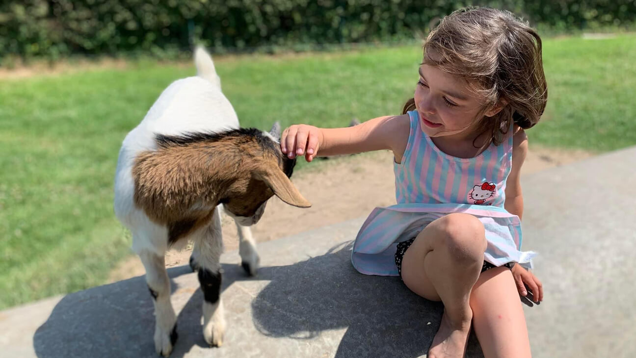 Kind bij een geit bij Kinderboerderij d'Oude Smelterij