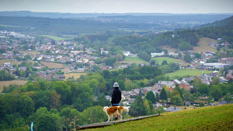 Man met hond kijkt uit over Rochefort