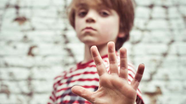 Een jongen steekt zijn hand uit en toont 5 vingers