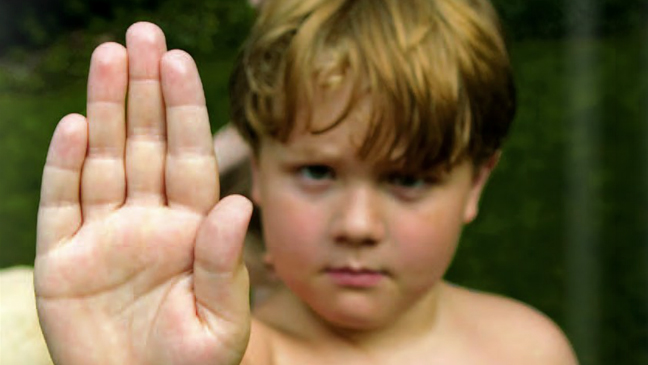 jongen maakt stop-gebaar