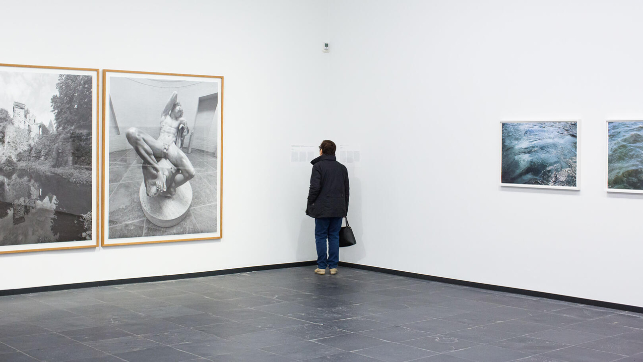 Galerij S.M.A.K. Gent met schilderijen en toerist die schilderijen staat te bewonderen.