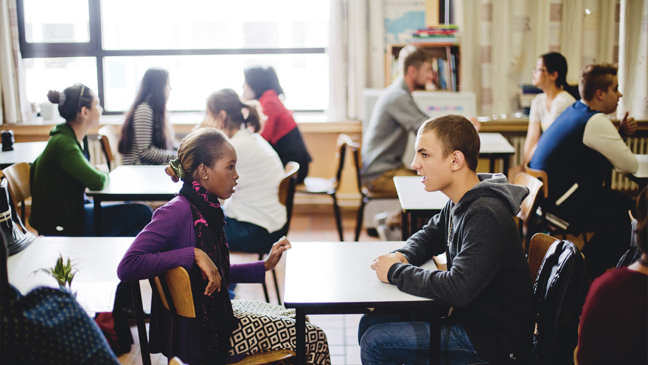 Twee okan-leerlingen praten met elkaar in de klas