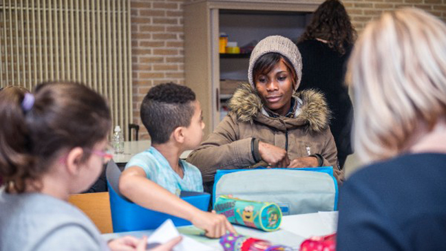 Vrouw helpt kinderen bij huiswerk