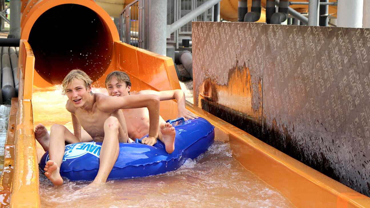 Twee jongens komen van een waterglijbaan tijdens een CLIP Taalvakantie