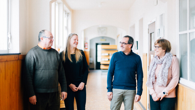 Leraren en oud-leerling in schoolgang