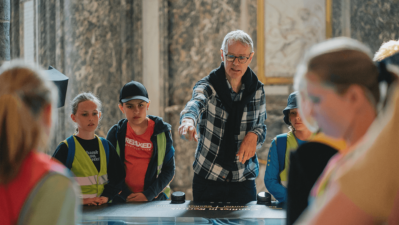 Klas bij een gids op de expo '1302: opstand, slag, keerpunt'