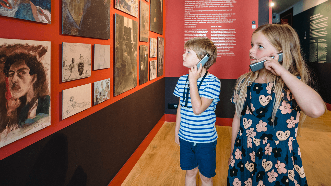 Kinderen luisteren naar audiogids in het James Ensorhuis