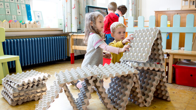 Kleuters bouwen toren met eierdozen