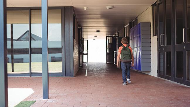 Jongen wandelt naar buiten met rugzak