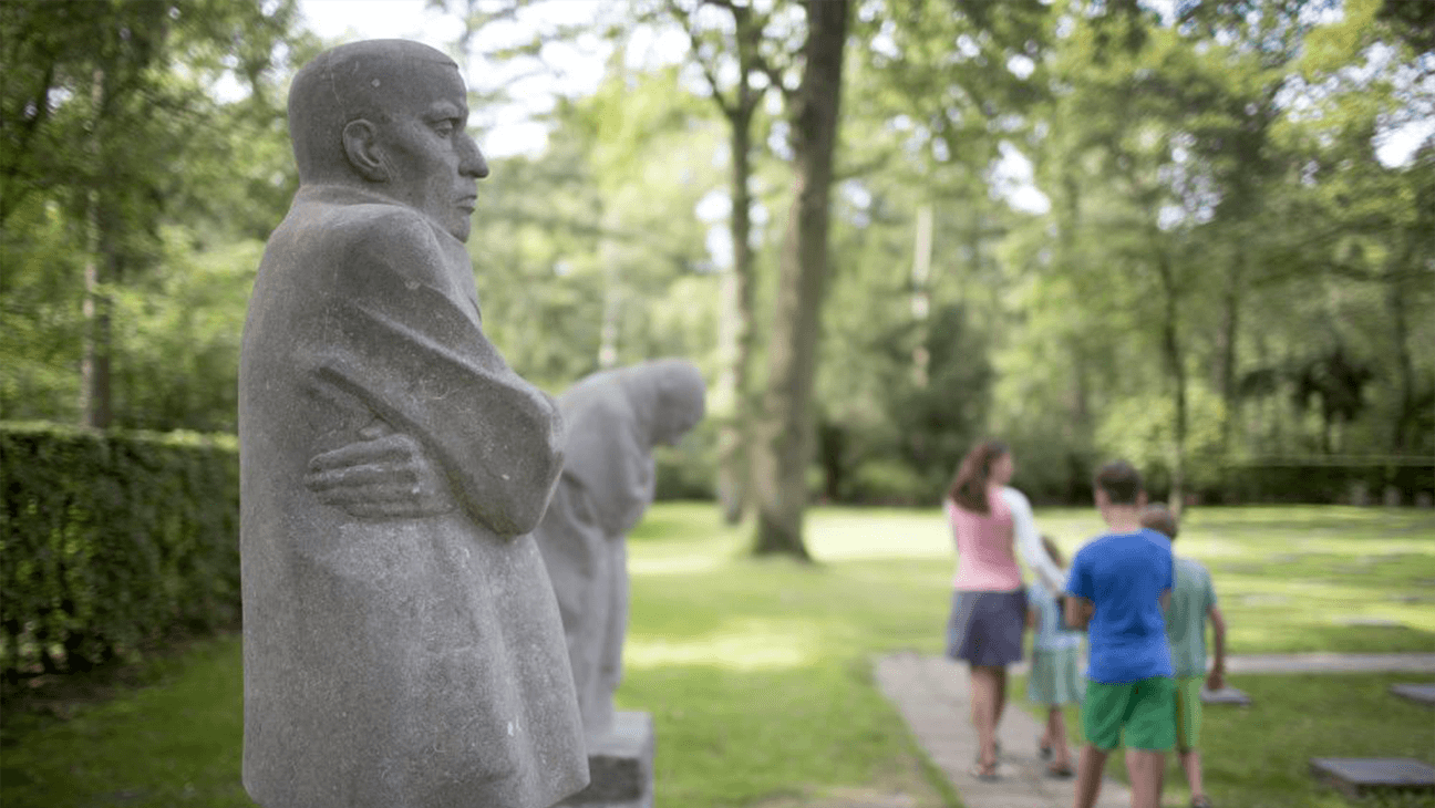 Gezin loopt voorbij een standbeeld in het Käthe Kollwitz Museum