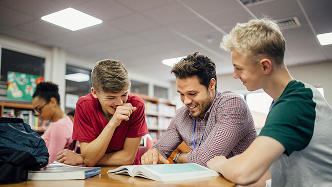 Leraar helpt leerlingen in de klas