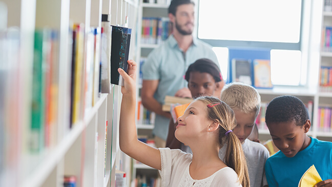 meisje neemt boek uit boekenrek in de klas