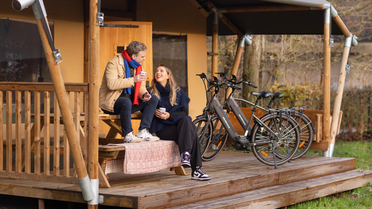 Twee personen aan tent met fietsen van Belgocycle