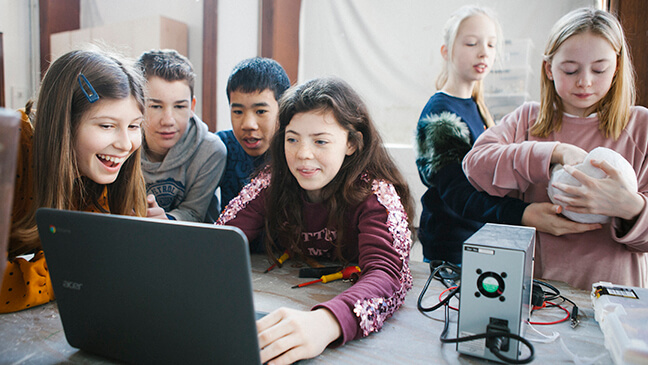 enkele leerlingen achter computer in de nieuwe school LAB
