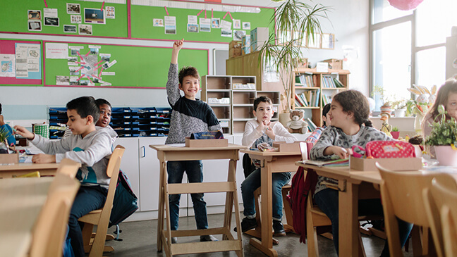 jongen aan een statafel in de klas