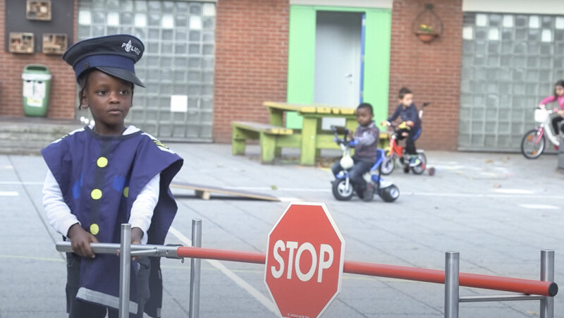 kind aan slagboom tijdens verkeersles