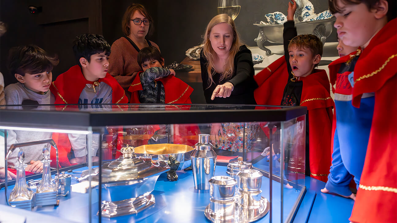 Klas kijkt naar zilveren bestek in DIVA museum
