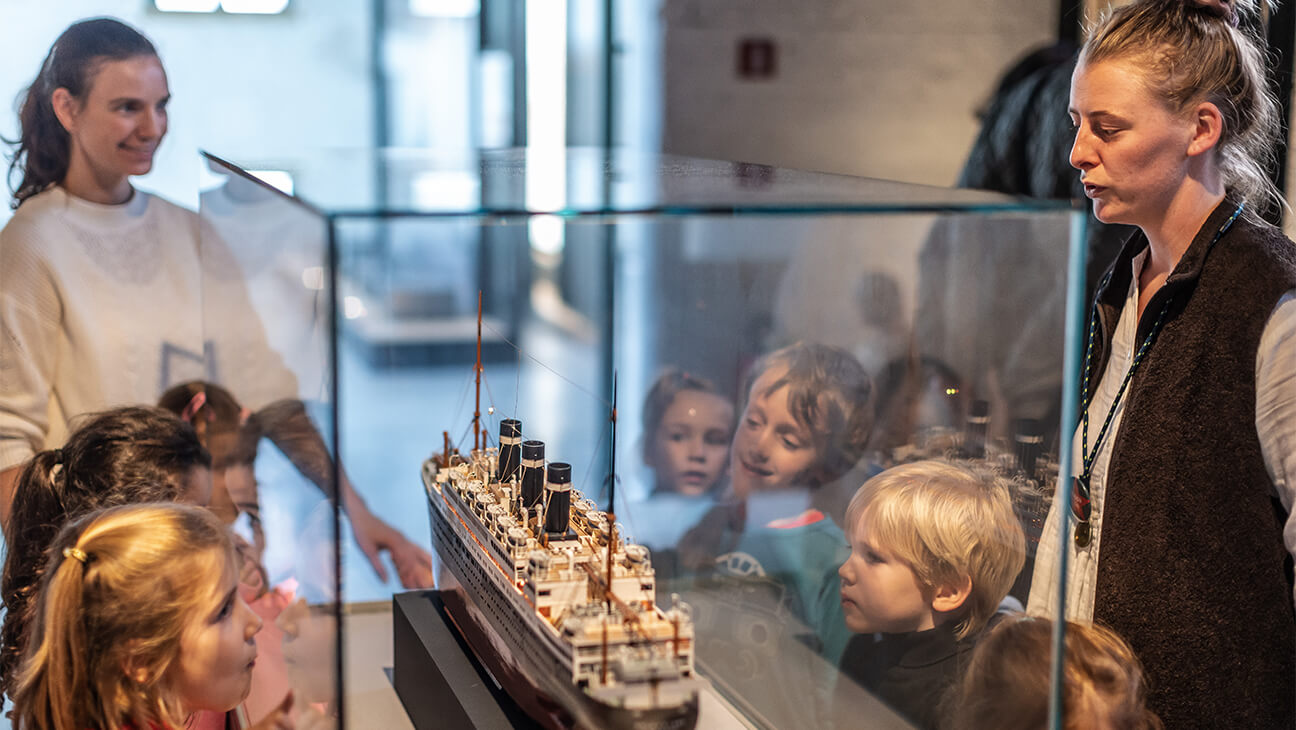 Kinderen kijken naar replica van een boot van red star line