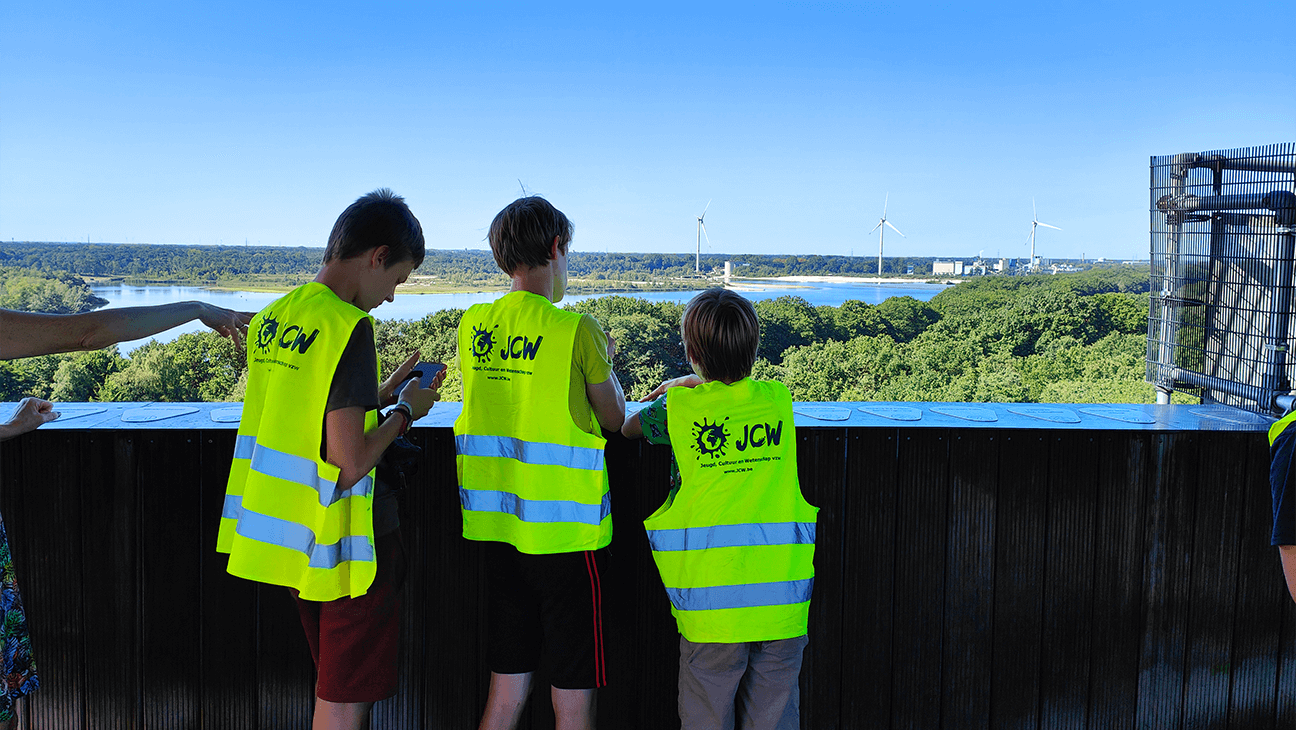 3 jongens uit een klas kijken naar windmolens