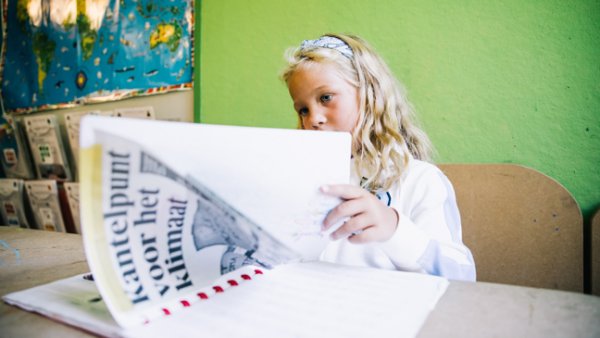 Meisje kijk in bundel met krantenknipsels