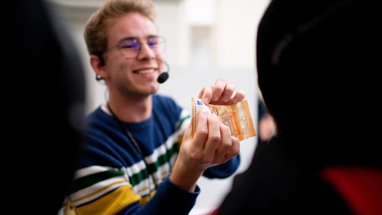 Gids toont merkteken op bankbiljet tijdens klasbezoek aan de Nationale bank in Brussel