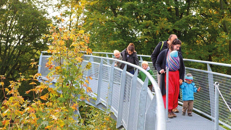 wandelaars op brug tussen de boomtoppen - Escale forestière