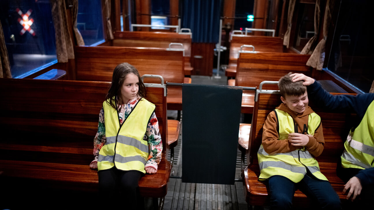 Leerling op bakstel in treinwagon tijdens klasbezoek aan trainworld in Brussel