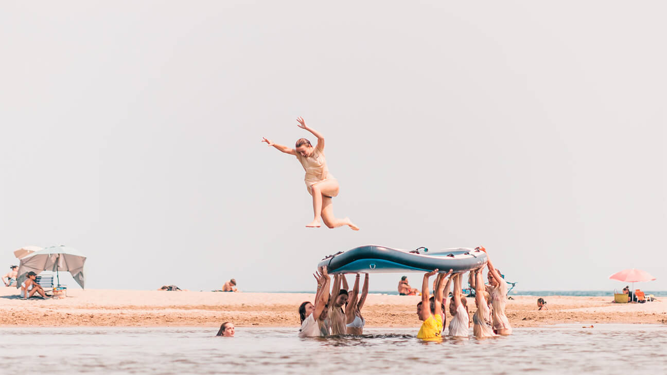 Groep met grote surfplank in zee