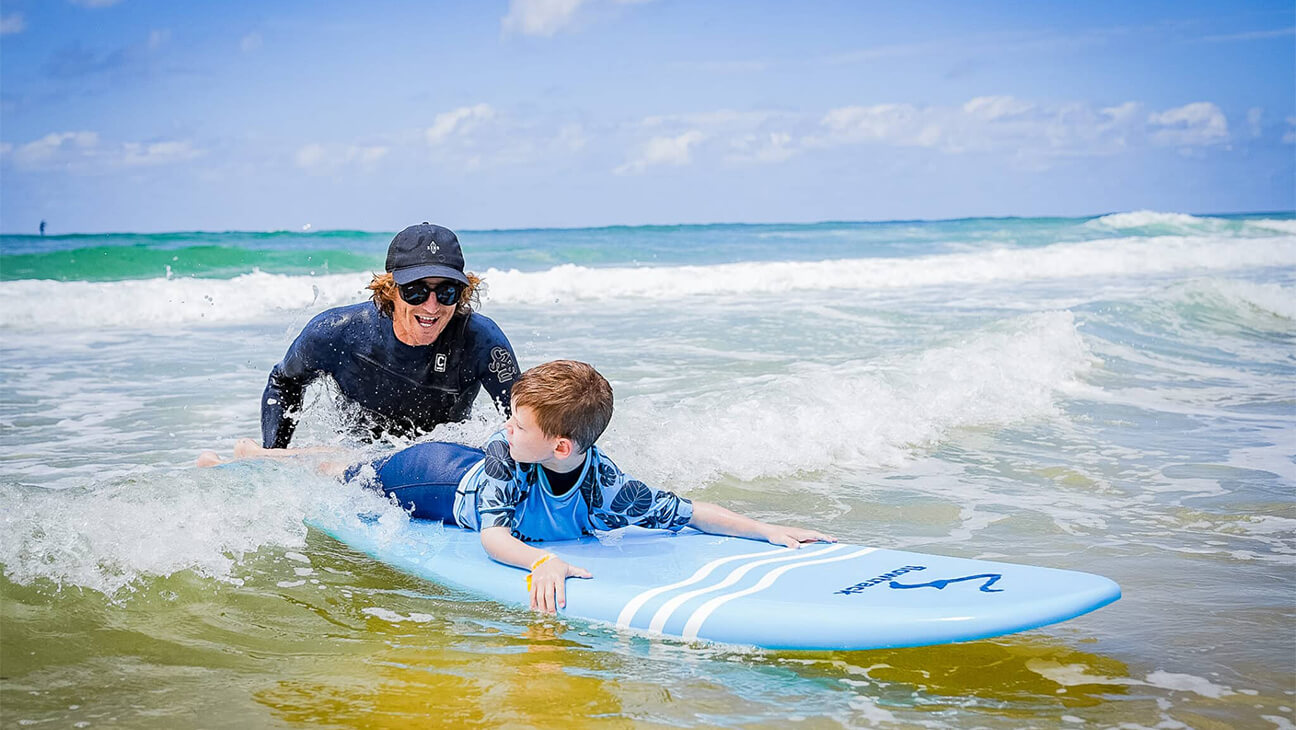 Gids leert kind surfen