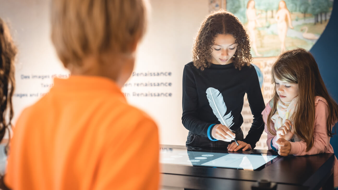 Jongeren werken op interactief-scherm in KBR museum